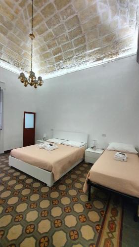 a bedroom with two beds and a ceiling at La Domvs del Borgo in Taranto