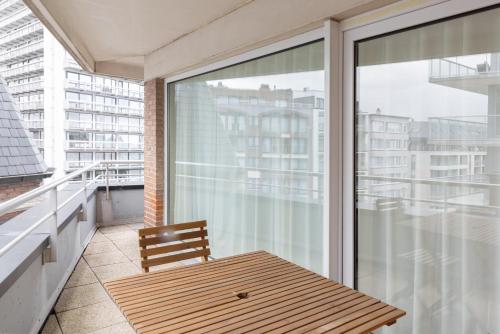 a wooden bench sitting on a balcony next to a window at Appartement Leo & De Walvis in Ostend