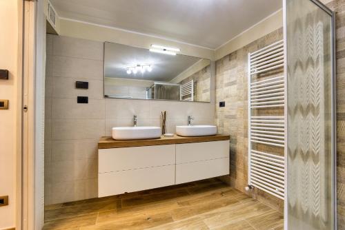 a bathroom with two sinks and a mirror at La Cantina Rent Rooms in Agliè