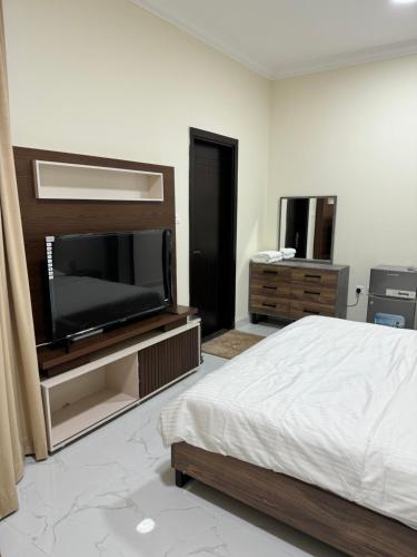 a bedroom with a bed and a flat screen tv at Hatta Gold Room in Hatta
