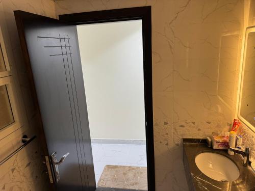 a bathroom with a toilet and a glass door at Hatta Gold Room in Hatta