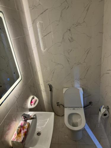 a bathroom with a white toilet and a sink at Hatta Gold Room in Hatta