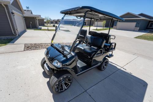 a golf cart is parked on a driveway at Fun House #265 w Water Park & Golf Cart in Arnolds Park