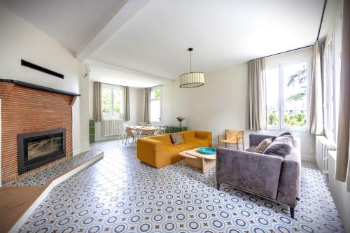 un salon avec un canapé et une cheminée dans l'établissement Gîte de la Futaie-Maison de caractère au calme, à Yvré-lʼÉvêque