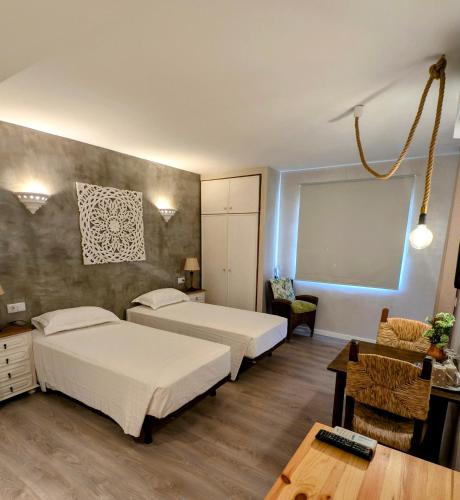 a hotel room with two beds and a table and a table sidx sidx at Casa Rosa Montes in Luz
