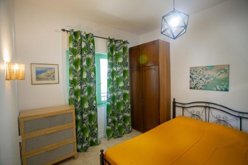 a bedroom with a bed and a dresser and a window at Morning Glory Apartment in Paralia Katerinis