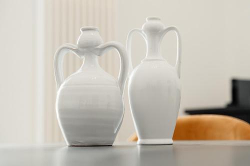 two white vases sitting on top of a table at Aparthotel Camere del Capitolo in Bisceglie