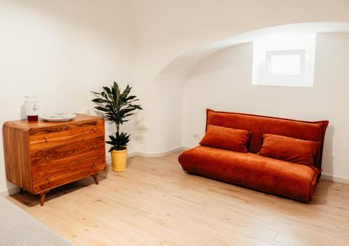 a living room with a couch and a wooden dresser at Aparthotel Camere del Capitolo in Bisceglie