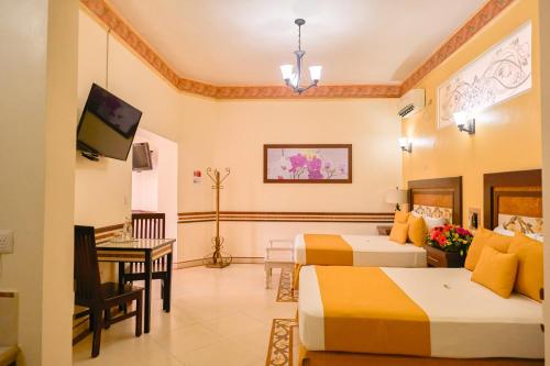a hotel room with two beds and a desk at Centro Hotel Villa las Margaritas in Xalapa