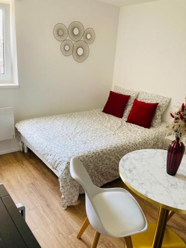 une petite chambre avec un lit et une table dans l'établissement Studio Cosy en centre-ville, à Saint-Brieuc