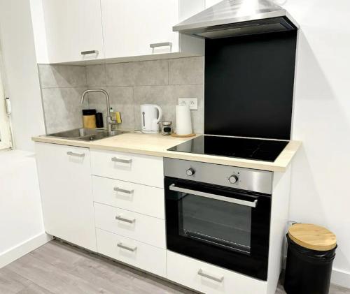 une cuisine avec une cuisinière et un évier dans l'établissement RS-0 - Appartement F2 au RDC à Mulhouse pour 1-3 pers, à Mulhouse