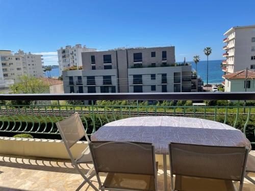 une table et des chaises sur un balcon avec vue sur l'océan dans l'établissement T3 Aperçu Mer, à Antibes