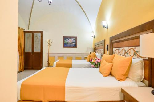 a hotel room with two beds with orange pillows at Centro Hotel Villa las Margaritas in Xalapa