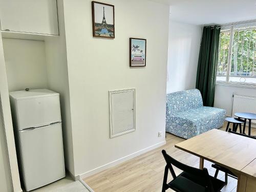 - un salon avec un réfrigérateur et une table dans l'établissement Charmant Appartement au Cœur du 13ème Arrondissement de Paris, à Paris