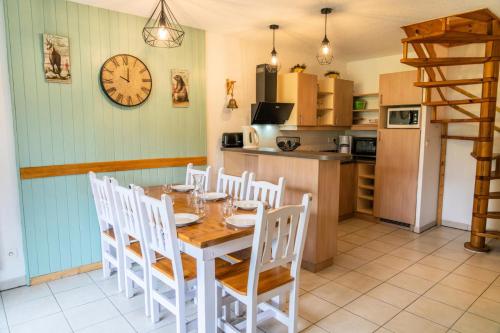 une cuisine avec une table et des chaises et une horloge au mur dans l'établissement Résidence Le Balcon Des Airelles - Joli appartement redécoré en face des pistes MAE-0774, aux Orres