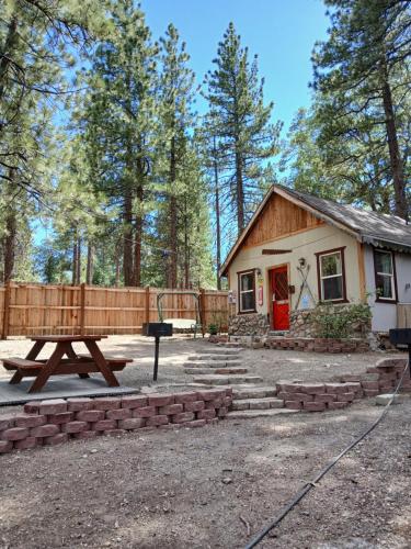 Una casa con una mesa de picnic delante de ella. en Big Bear Lake - Tulip Lane Cabin #26, en Big Bear Lake