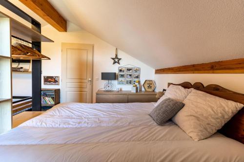 - une chambre avec un grand lit blanc et une tête de lit en bois dans l'établissement Résidence Les Hauts De Preclaux - Magnifique appartement refait à neuf aux Orres MAE-1131, aux Orres