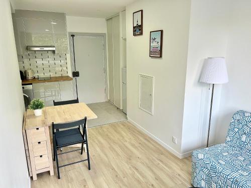 un salon avec une table et une chaise dans l'établissement Charmant Appartement au Cœur du 13ème Arrondissement de Paris, à Paris
