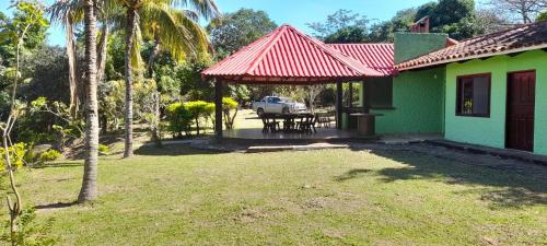 une maison verte avec un toit rouge avec une table de pique-nique dans l'établissement Quinta El Mirador en Peji, à Santa Cruz de la Sierra