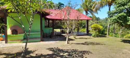 une maison verte avec un toit rouge dans une cour dans l'établissement Quinta El Mirador en Peji, à Santa Cruz de la Sierra