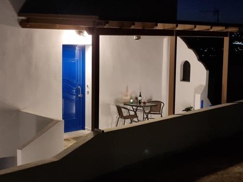 a room with a blue door and a table at Maitos Apartments in Galanado