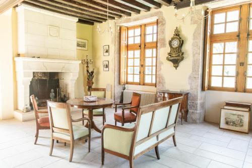 un salon avec une table et des chaises et une cheminée dans l'établissement Château de Conon Gite le Château, à Cellettes