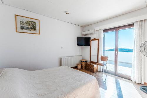 a white bedroom with a bed and a large window at Mountain view 6 bed mansion with Private Padel Court, Pool & Gym in Larnaka
