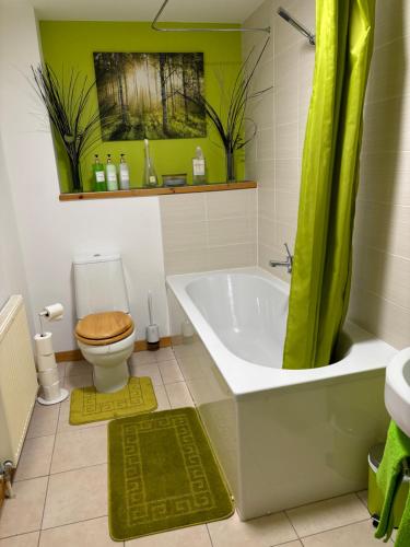 a bathroom with a tub and a toilet and a sink at MacIver City Apartments Farraline Court in Inverness