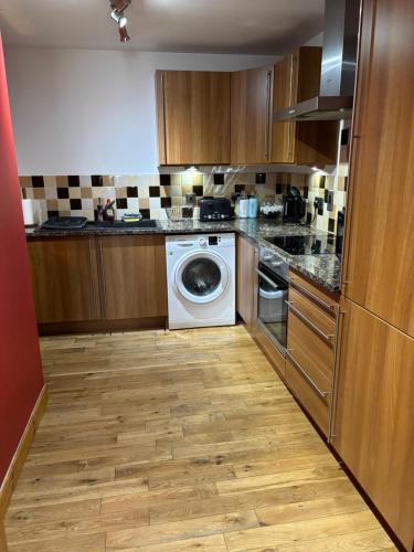 a kitchen with a washing machine and a washer at MacIver City Apartments Farraline Court in Inverness