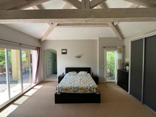 - une grande chambre avec un lit et de grandes fenêtres dans l'établissement Charming villa surrounded by nature, à Simiane-Collongue