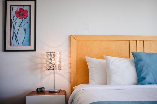 a bedroom with a bed and a lamp on a table at Riôtel Carleton-sur-Mer in Carleton sur Mer