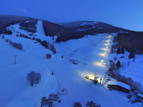 a snow covered slope with lights on it at night at Chalúpky pod Viaduktom in Telgárt