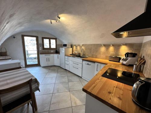 une cuisine avec des armoires blanches et un comptoir dans l'établissement Chalet Le Chatelret - LE CHATELRET MAE-9361, à Vars