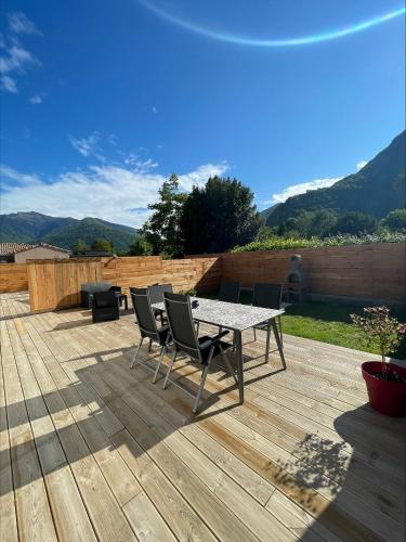 a patio with a table and chairs on a wooden deck at Gîtes de Chaum in Chaum
