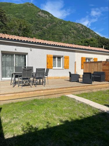 a wooden deck with a table and chairs on it at Gîtes de Chaum in Chaum