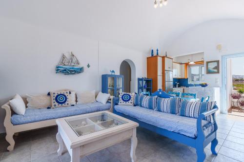un soggiorno con due divani blu e un tavolo di Blue Eyes Beach Villas a Monolithos
