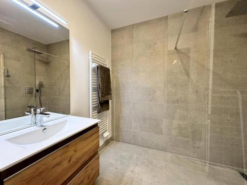 une salle de bain avec un lavabo et une douche en verre dans l'établissement Résidence Le Solea - RESIDENCE LE SOLEA SAUNA ET SPA-Tout inclus MAE-4501, à Vars