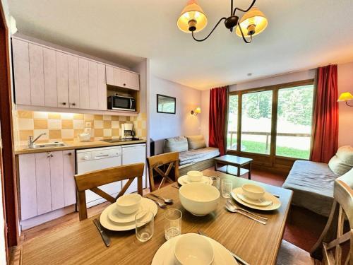 une cuisine et un salon avec une table et des chaises dans l'établissement Résidence L'albane - L'ALBANE - pied de pistes avec accès PISCINE - MAE-4521, à Vars