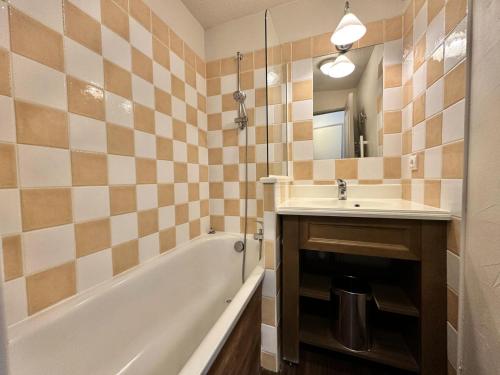 une salle de bain avec une baignoire et un lavabo et une baignoire dans l'établissement Résidence L'albane - L'ALBANE - PARTIR DEPUIS LA TERRASSE EN SKIS MAE-4531, à Vars