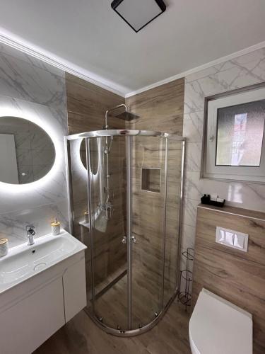 a bathroom with a shower and a toilet and a sink at Apartmani Stars in Sarajevo