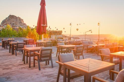 a restaurant with tables and chairs and an umbrella at Breeze Of Cappadocia in Uchisar