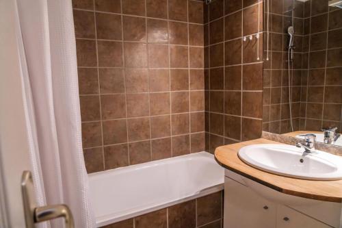 une salle de bain avec une baignoire et un lavabo et une baignoire dans l'établissement Les Chalets De Bois MÉan - A - Appartement calme aux Orres 1800 MAE-9931, aux Orres