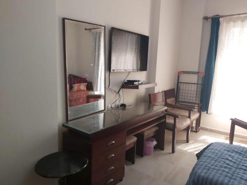 - une chambre avec un bureau avec un miroir et un lit dans l'établissement Aqua View Resort studio, North Coast, منتجع اكوا فيو الساحل الشمالي, à El Qasaba esh Sharqīya
