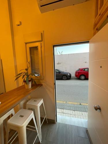 a room with a counter with two stools and a mirror at Apartamento de la Luz in Tarifa