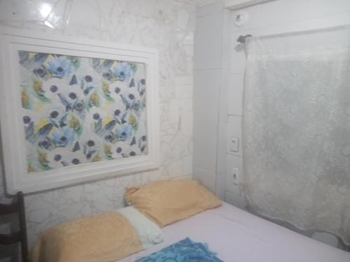 a bedroom with a bed and a painting on the wall at Suites casa da lucia in Salvador