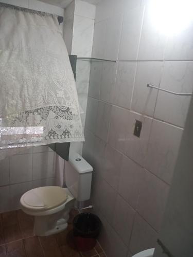 a small bathroom with a toilet and a shower at Suites casa da lucia in Salvador