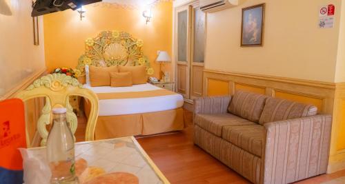 a room with a bed and a couch in a room at Villa las Margaritas Plaza Cristal in Xalapa