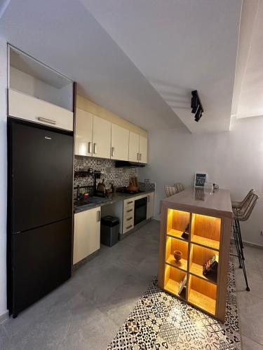 a kitchen with a black refrigerator and a table at Studio minimaliste marbella beach in Mansouria