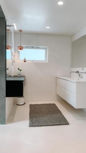 a white kitchen with a sink and a rug at Modern house 5 bedrooms 2 baths sentral in Bodø