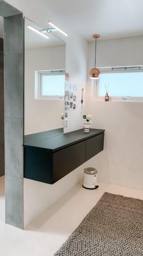 a bathroom with a black counter and a mirror at Modern house 5 bedrooms 2 baths sentral in Bodø